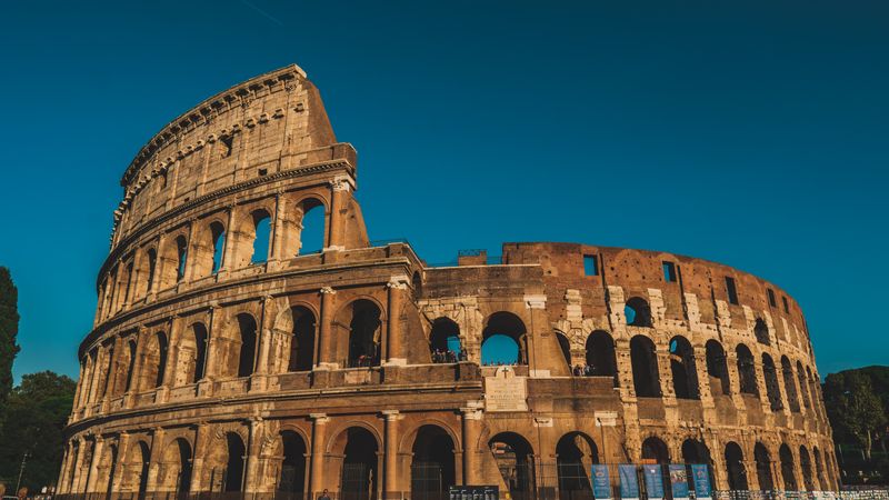 The Colosseum in Rome under a blue sky