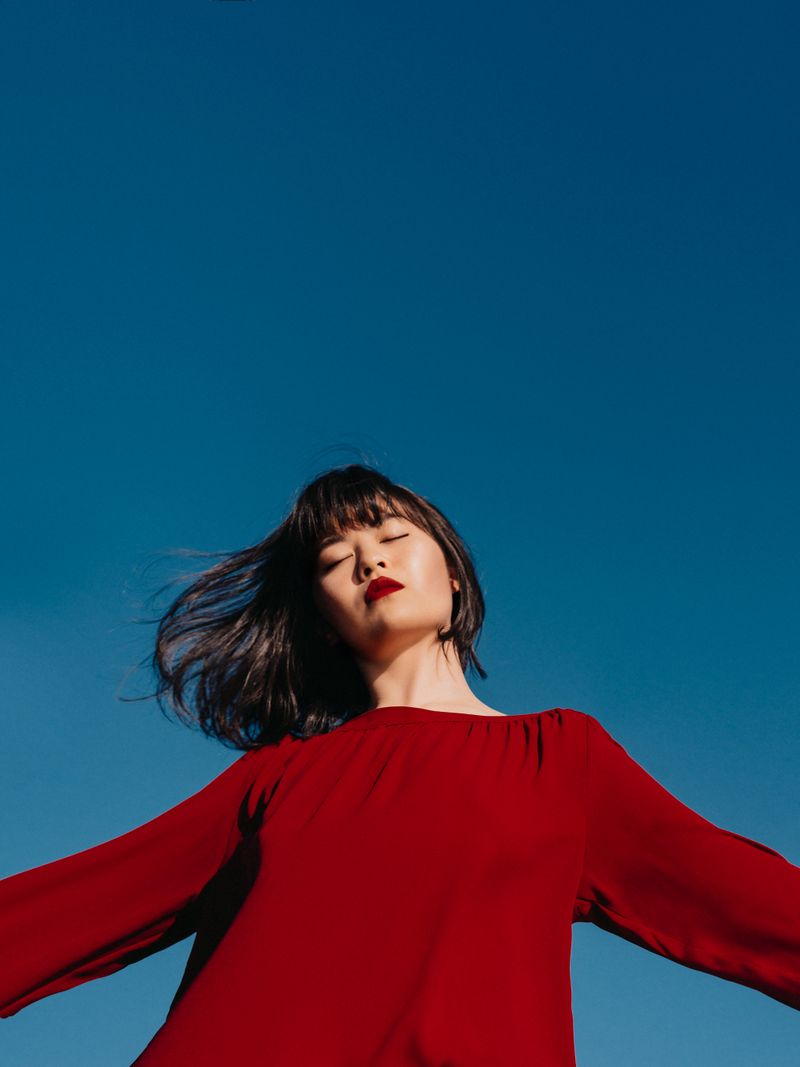 A woman in red against a deep blue sky
