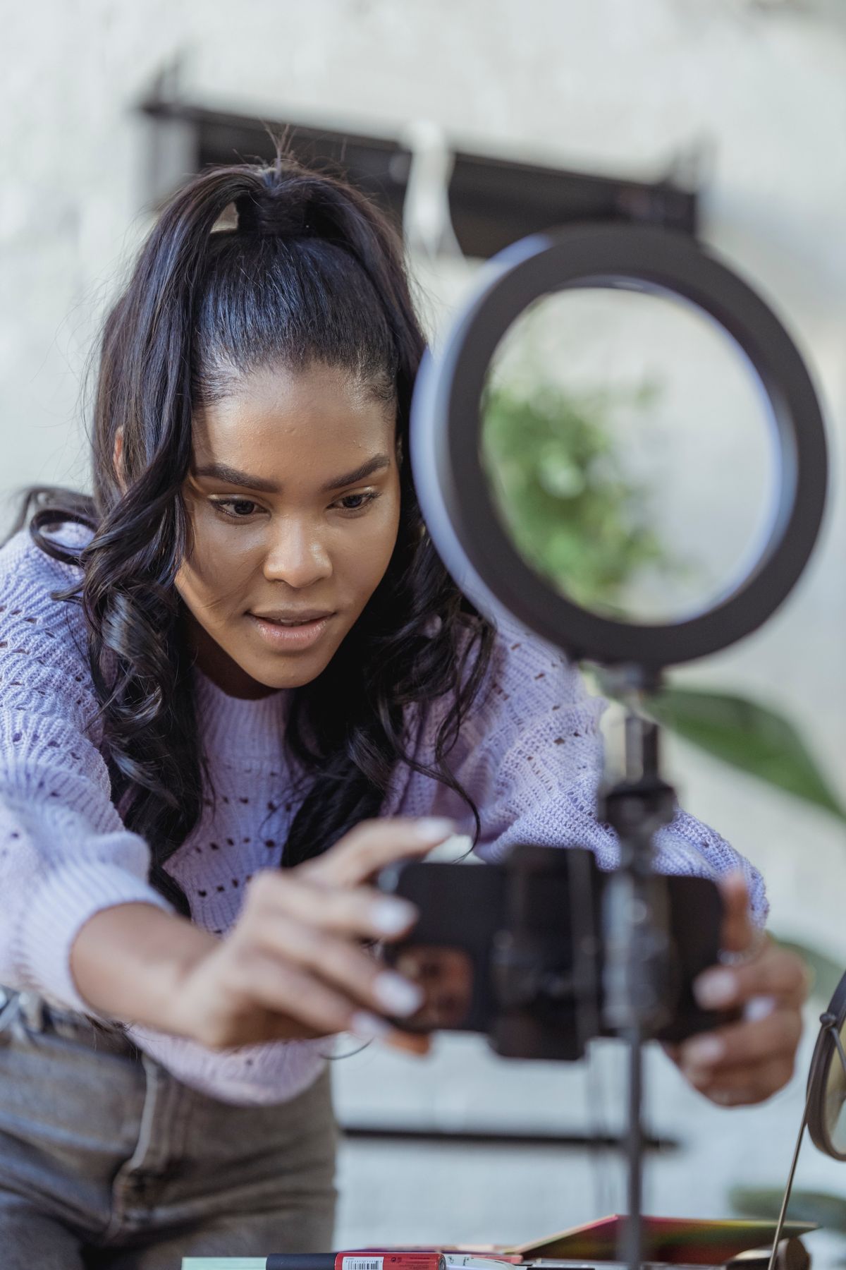 A creator setting up a phone on a ring light to record
